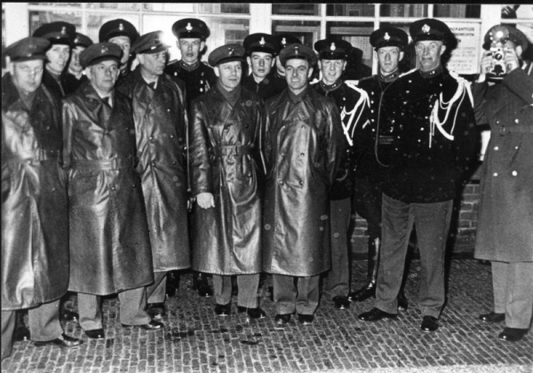 Foto van het personeel van douane en Marechaussee voor het grenspostgebouw bij de grensovergang Elten - Hüthum in 1962. Van links naar rechts: de eerste douanier Ooyink, de vierde Smits (woonde Emmerichseweg 2), de achtste Van Leeuwen, de veertiende (is tweede van rechts) Breeman. De foto is gemaakt in de periode dat Elten bij Nederland hoorde vanaf 23 april 1949 tot 1 augustus 1963. Dat het gaat om 1962, mogelijk 1963, is te zien aan het type uniform van de Marechaussees. Deze uniformen zijn namelijk pas in 1962 ingevoerd.