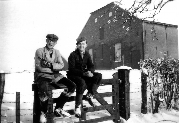 Boerenknechten Jan Driessen (links) en Henk Huuskes tijdens een pauze zittend op een hek, ca. 1952