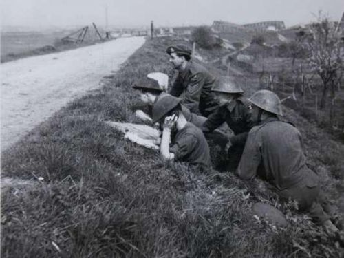 Soldaten in dekking achter een dijk