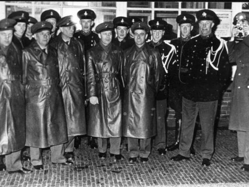 Foto van het personeel van douane en Marechaussee voor het grenspostgebouw bij de grensovergang Elten - Hüthum in 1962. Van links naar rechts: de eerste douanier Ooyink, de vierde Smits (woonde Emmerichseweg 2), de achtste Van Leeuwen, de veertiende (is tweede van rechts) Breeman. De foto is gemaakt in de periode dat Elten bij Nederland hoorde vanaf 23 april 1949 tot 1 augustus 1963. Dat het gaat om 1962, mogelijk 1963, is te zien aan het type uniform van de Marechaussees. Deze uniformen zijn namelijk pas in 1962 ingevoerd.