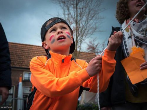 Kind met rood-wit-blauwe vlag op wangen houd touw vast