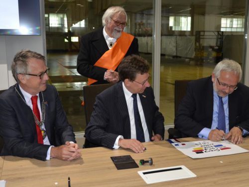 Op de foto werd de overdracht nagespeeld. Rechts: Thomas Hartmann, Abteilungsdirektor Im Regierungsbezirk Düsseldorf en daarnaast Clemens Cornielje, Commissaris der Koning van Gelderland. Links burgemeester Jan de Ruiter.