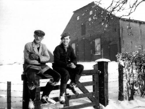 Boerenknechten Jan Driessen (links) en Henk Huuskes tijdens een pauze zittend op een hek, ca. 1952