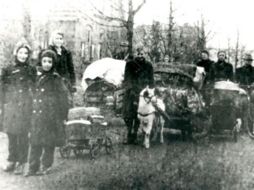 Foto van de evacuatiestroom door Nieuw-Dijk aan het eind van de Tweede Wereldoorlog. Lobithse vluchtelingen trekken door de Smallestraat in Nieuw-Dijk. Op de foto de families Van Burck en Naterop. Het meisje vooraan links is de 10-jarige  Ria van Burck (gehuwd Hoogveld) met naast haar haar broertje John. Achter haar staat haar moeder en de man met de hoed achter de met een zeil afgedekte kar, is haar vader. De bok wordt geleid door Theo Naterop, Harrie Natrop (14 jaar) is te zien naast de man met de fiets. Bijna verscholen achter de kar (je ziet alleen zijn hoofd) staat Jan Naterop toen 16 jaar oud. De families Van  Burck en Naterop waren buren en deelden 's -nachts een kelder omdat de geallieerden vanuit Kleef en Nijmegen op de Duitse stellingen bij Arnhem schoten. Vanwege het gevaar is de Liemers ten oosten van de spoorlijn Arnhem-Zevenaar geëvacueerd. De voettocht ging van Tolkamer  naar Herwen waar ze een paar dagen bleven. Van de familie Wijnker kregen ze een bok en een kar voor hun spullen. De enige die goed met het dier om kon gaan was Theo Naterop. Tijdens de tocht vanuit Herwen, via Nieuw-Dijk, naar Doetinchem was het heel erg koud. Volgens Harrie Naterop lag overal ijs. Uiteindelijk kwamen de families bij een familie in Westendorp bij Varsseveld terecht. De familie Van Burck verbleef daar bij de familie Lettink en Ria van Burck heeft goede herinneringen aan de tijd dat ze in Westendorp verbleef. (informatie uit de Gelderlander van 25 mei 2010 die de foto eerder dit jaar (april) publiceerde wat vervolgens deze reactie opriep