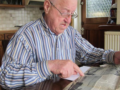 Willie wijst een foto aan in een artikel uit de Gelderlander van 1940 over blokken ijs in de winter van 1940.